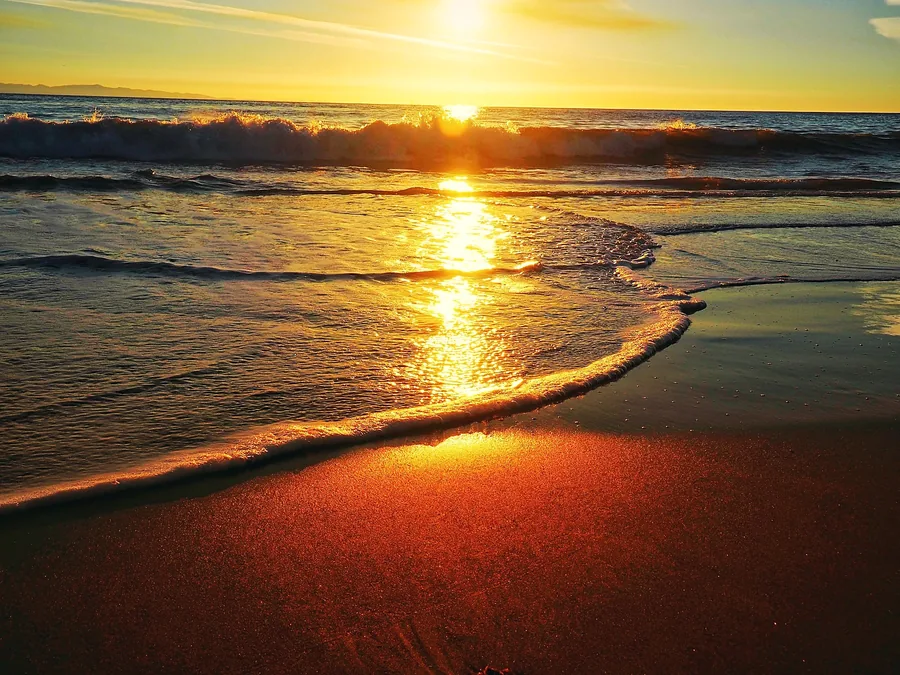 Praia ao pôr do sol (imagem ilustrativa)